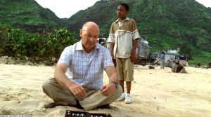 Walt approaches Locke while he plays backgammon on the beach